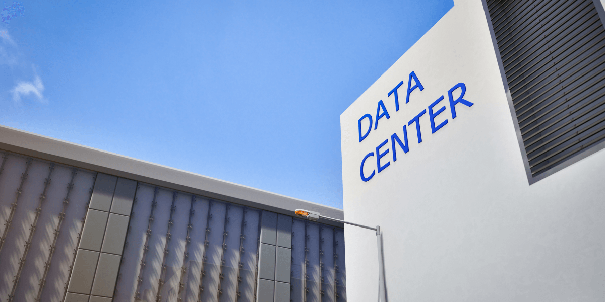 Modern data center building with a clear blue sky above and signage.