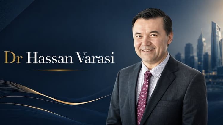Portrait of Dr. Hassan Varasi in business attire beside city skyline, promoting leadership and customer experience in business.