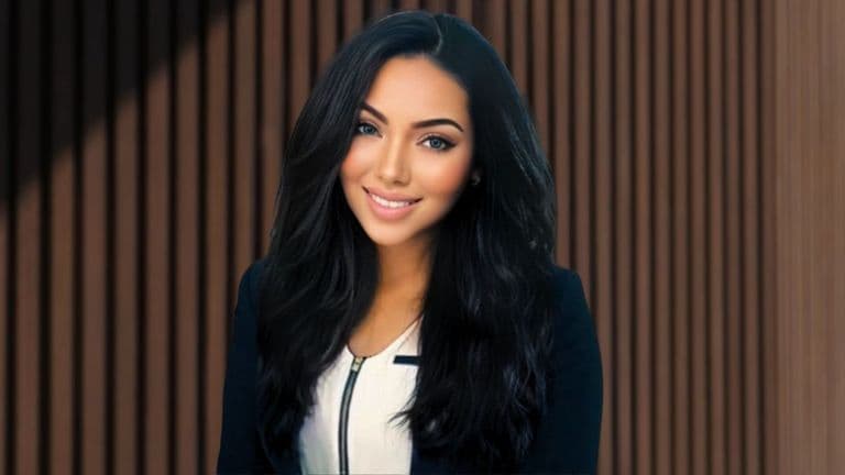 Portrait of a confident woman in a business suit, smiling with long black hair, standing in front of a brown wooden wall, conveying professionalism and elegance.