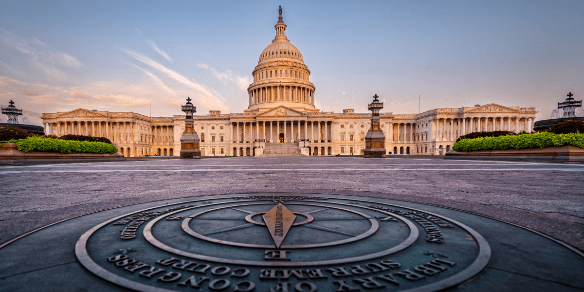The U.S. Capitol building at sunrise, featuring a prominent compass rose in the foreground