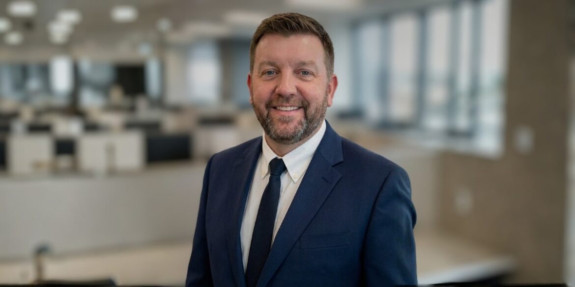 Scott Buchanan, CEO of CoreLabs AI, stands confidently in a professional setting, exemplifying leadership in AI transformation.